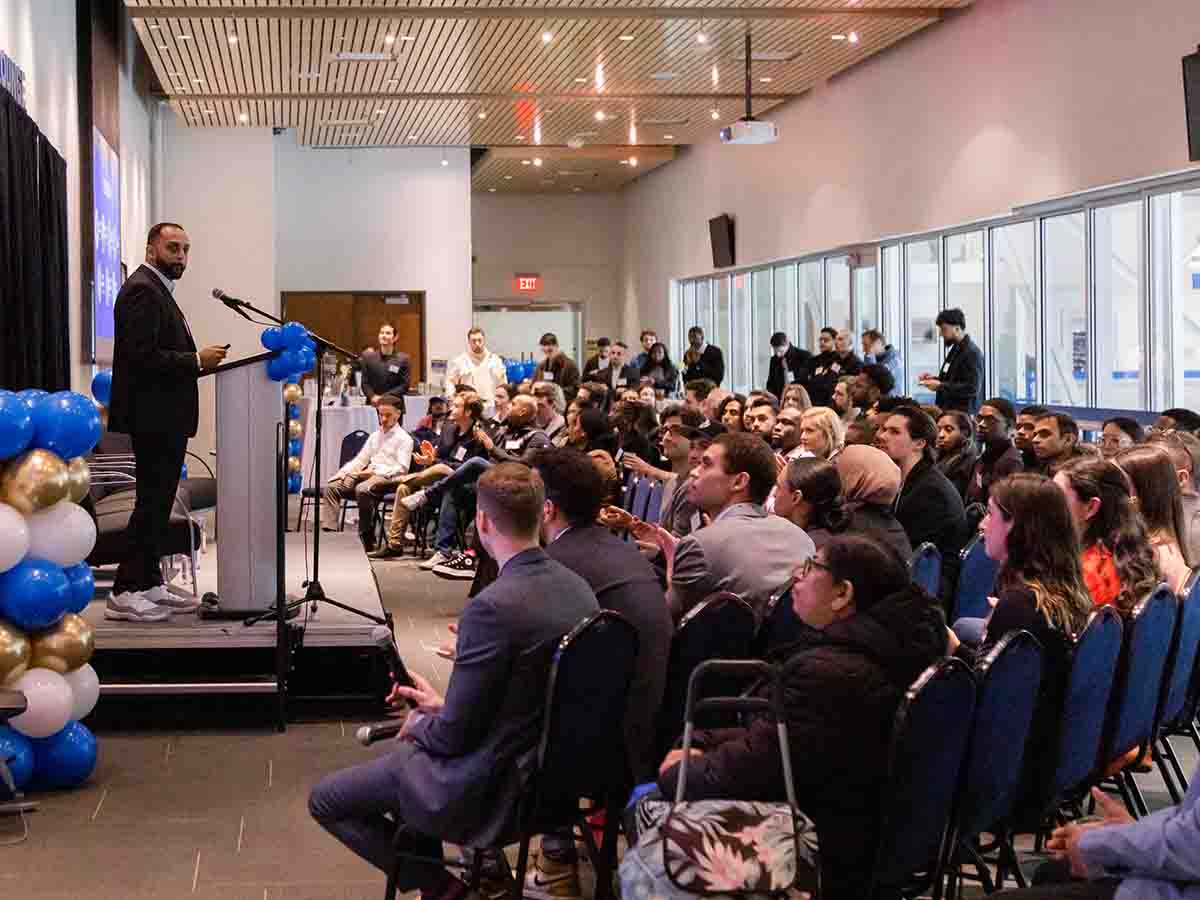 Speaker at podium and large crowd in the audience at MBA event